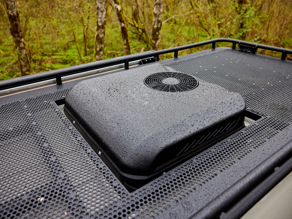 Roof-mounted air conditioning unit on a vehicle with a forest background