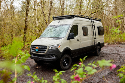 White van with roof rack on a forest road