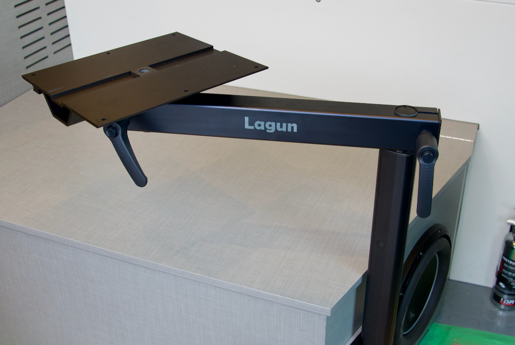 Lagun table leg system in black anodized aluminum finish with dark tabletop attached, showing arm and locking knobs