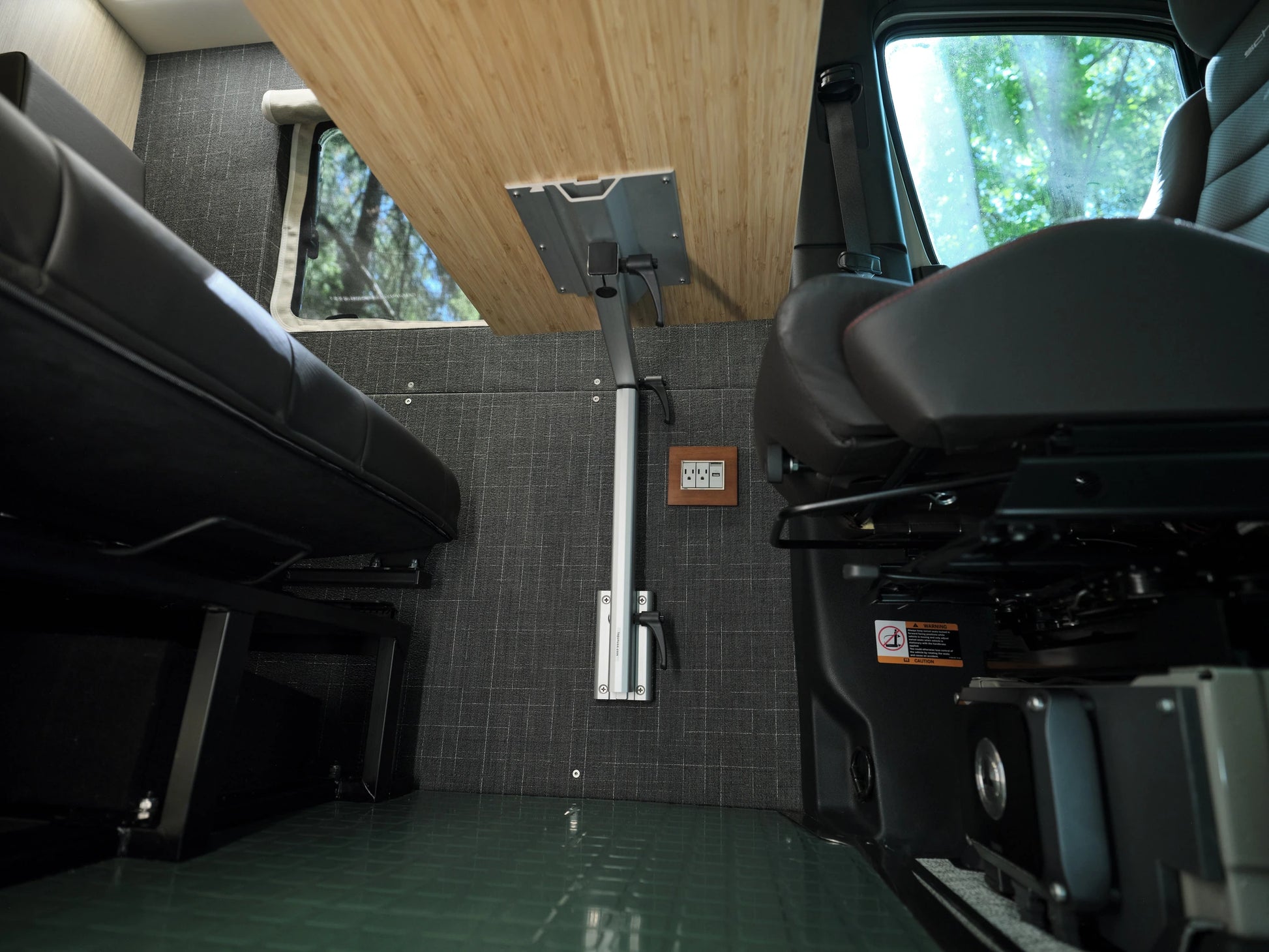 Nomad Vanz Sprinter interior showing the Lagun swivel table mount post and power outlet between the bench and cab seats
